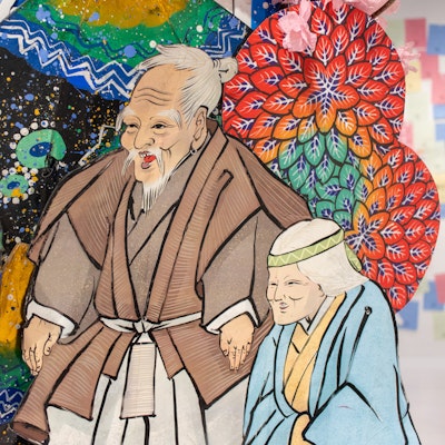 Close-up of a brightly coloured, traditional drawing of two figures.