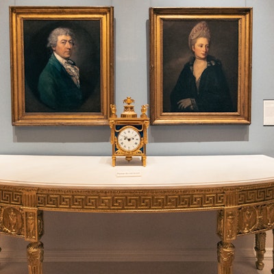 A clock and two portraits in the Courtault Gallery