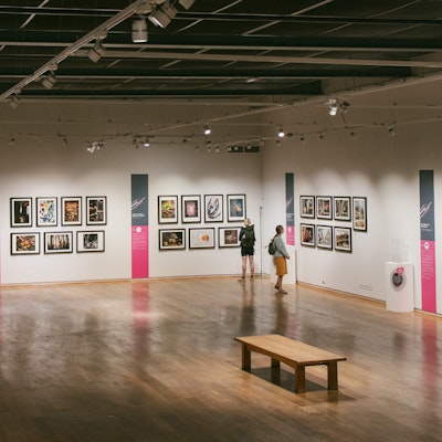 Photo of people viewing some photographs on display at the galleries.