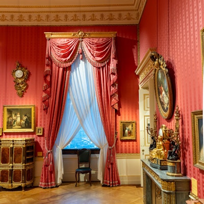 Photo of a large, curtained window in the boudoir of the house.