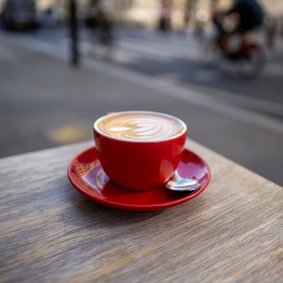 Photo of a flat white in a red cup.