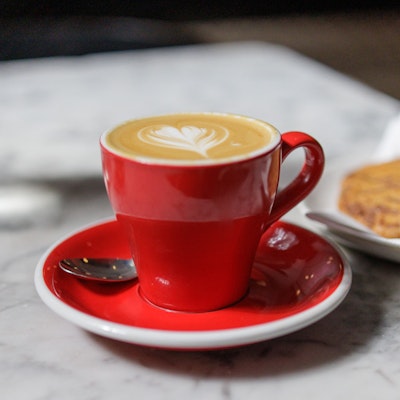 Photo of a flat white in a red cup.