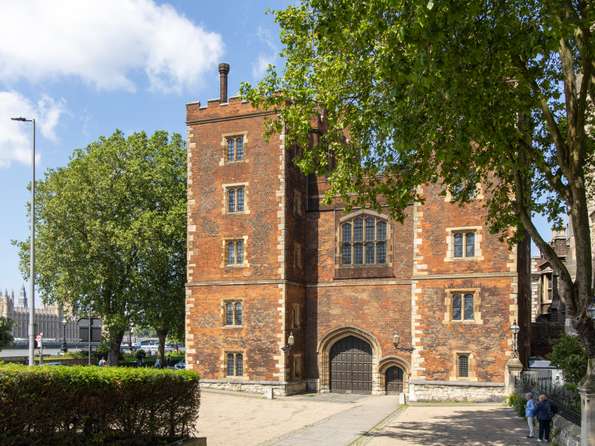 The front of Lambeth Palace, a gothic red brick square tower.