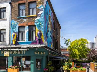 Picture of a Thai restaurant in a Victorian Building, faced with colourful murals.