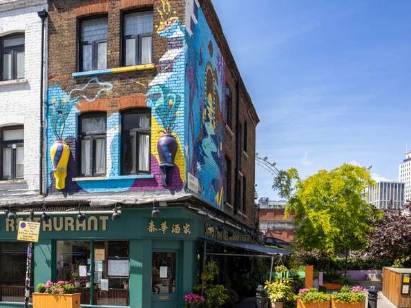 Picture of a Thai restaurant in a Victorian Building, faced with colourful murals.