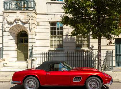 Photo of a Ferrari parked at the front of a Palladian building.