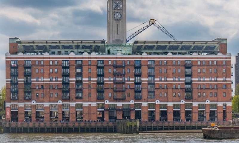 The Oxo Tower with the muddy Thames in the foreground.