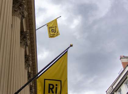 A picture of yellow flags flying at the front of the Royal Institution