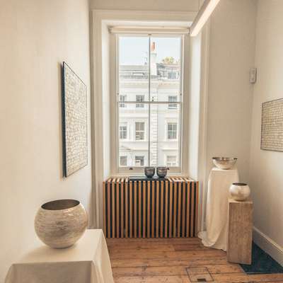 Photo of some pottery displayed next to a window.