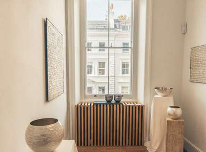 Photo of some pottery displayed next to a window.