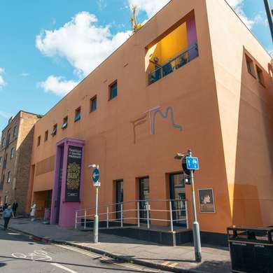 Photo of the exterior of the museum, a modern, orange building