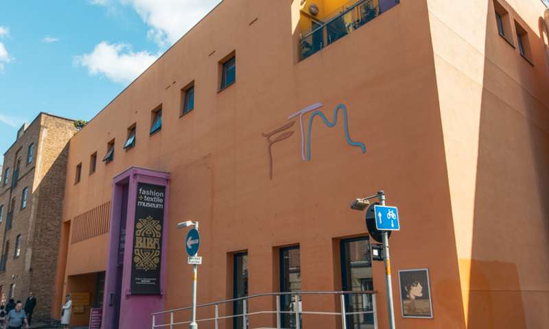 Photo of the exterior of the museum, a modern, orange building