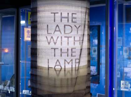 Photo of a large replica lamp with "The Lady of the Lamp" projected onto it.