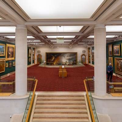 Photo in the Guildhall Art Gallery, showing people looking at Victorian paintings.