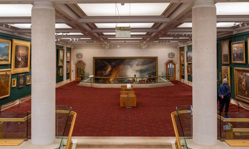 Photo in the Guildhall Art Gallery, showing people looking at Victorian paintings.