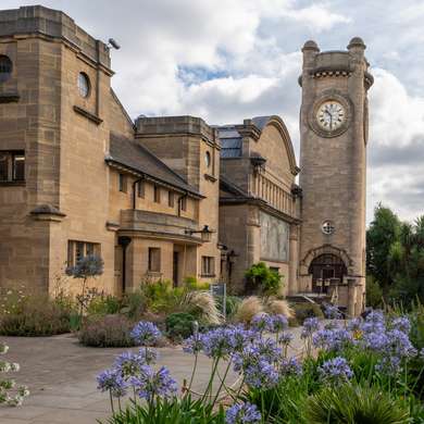 Photo of the clock tower with blue flowers in the foreground.