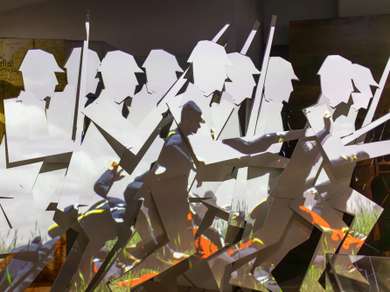 A video is projected onto an angular backdrop depicting advancing soldiers.