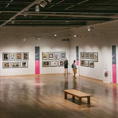 Photo of people viewing some photographs on display at the galleries.