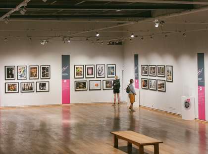 Photo of people viewing some photographs on display at the galleries.