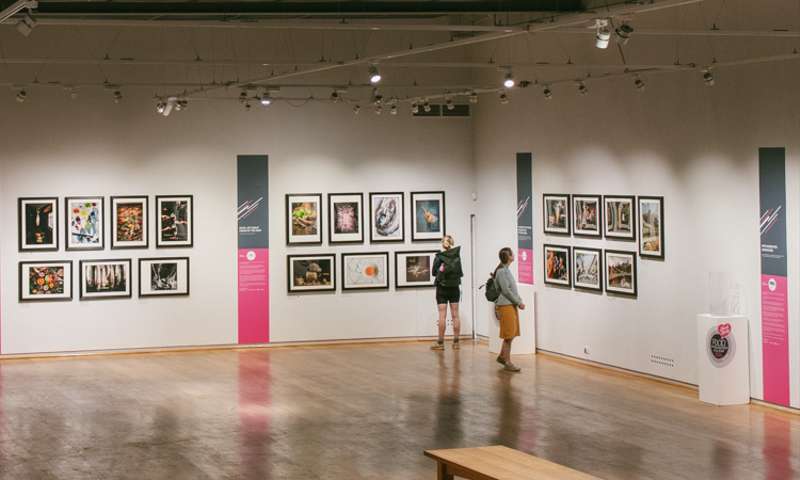 Photo of people viewing some photographs on display at the galleries.