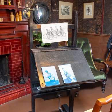 A desk with a sketch of some people on a tandem alongside photographs of the same.