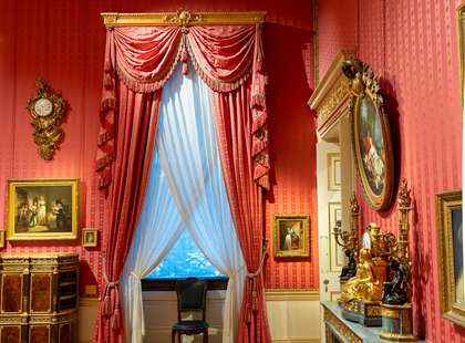 Photo of a large, curtained window in the boudoir of the house.