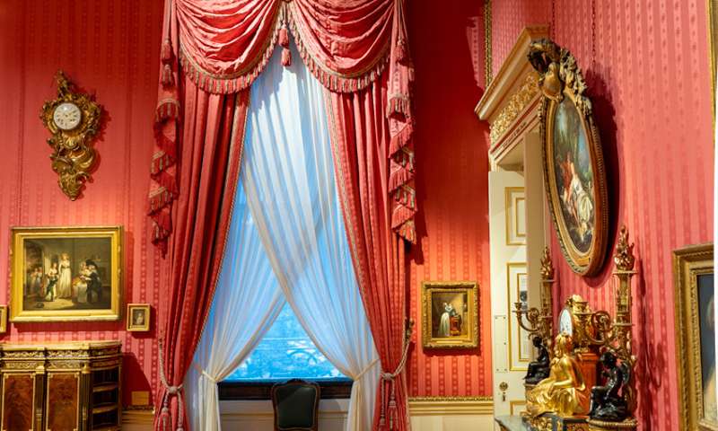 Photo of a large, curtained window in the boudoir of the house.