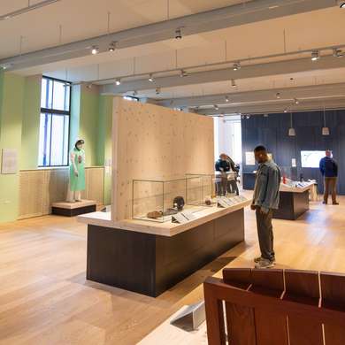 Photo of people looking at exhibits in the Being Human exhibition at the Wellcome Collection