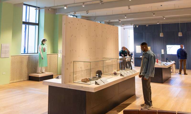 Photo of people looking at exhibits in the Being Human exhibition at the Wellcome Collection
