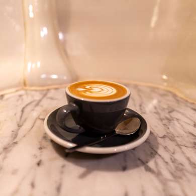 Photo of a flat white on a bar table created from a urinal. Lovely.